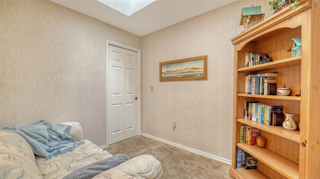 7426 Weeping Willow Boulevard Sarasota, FL 34241 - Photo 45 of 66 a bedroom with a bed and a book shelf