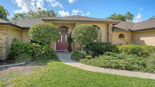a view of a house with a yard and potted plants