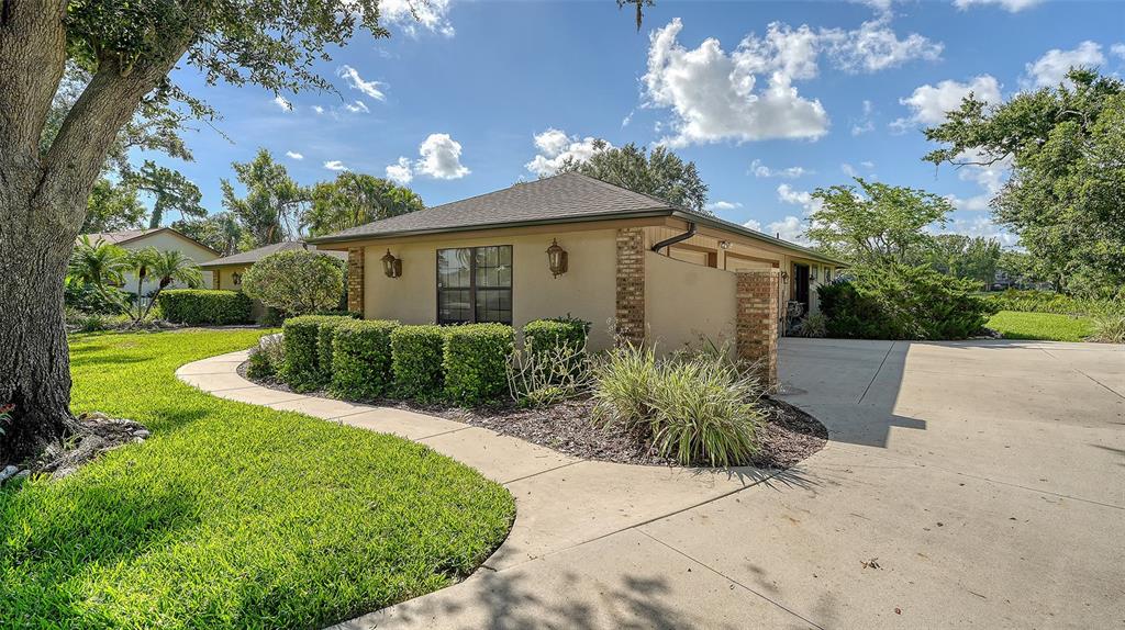 7426 Weeping Willow Boulevard Sarasota, FL 34241 - Photo 8 of 66 a view of a house with a yard and potted plants