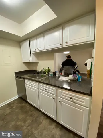 a kitchen with granite countertop white cabinets and white appliances