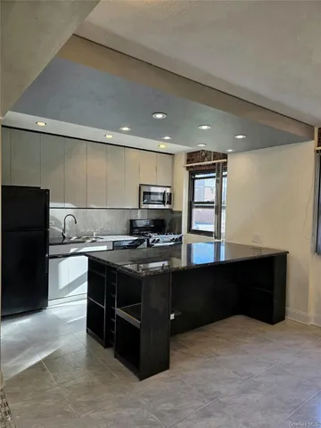 a kitchen with stainless steel appliances granite countertop a stove a sink and a refrigerator