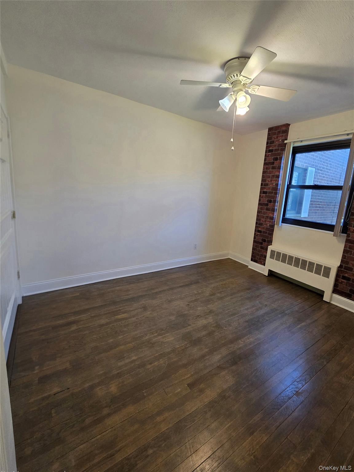 86-06 155th Avenue, Unit 4 Queens, NY 11414 - Photo 9 of 11 a view of an empty room with wooden floor and a ceiling fan