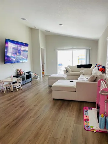 a living room with furniture and a wooden floor