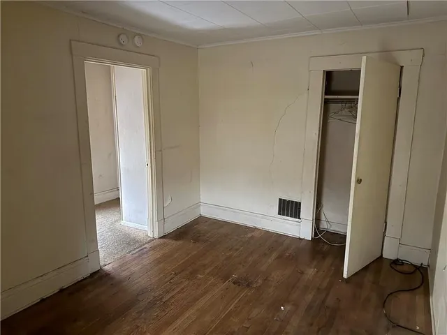 an empty room with wooden floor and closet