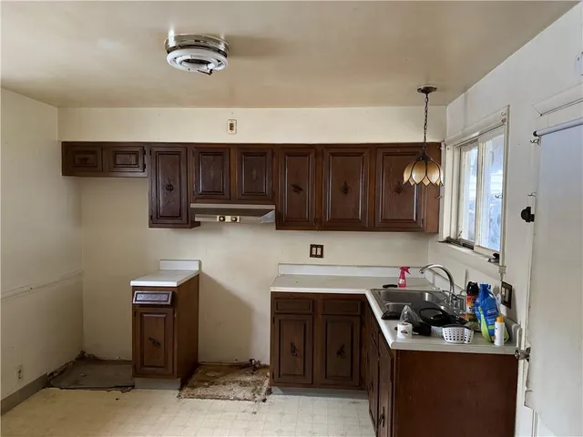 a kitchen with a sink a stove and cabinets