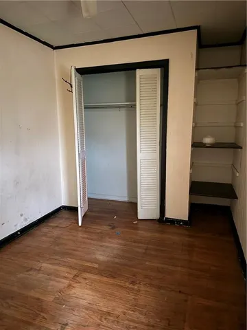 an empty room with wooden floor and closet