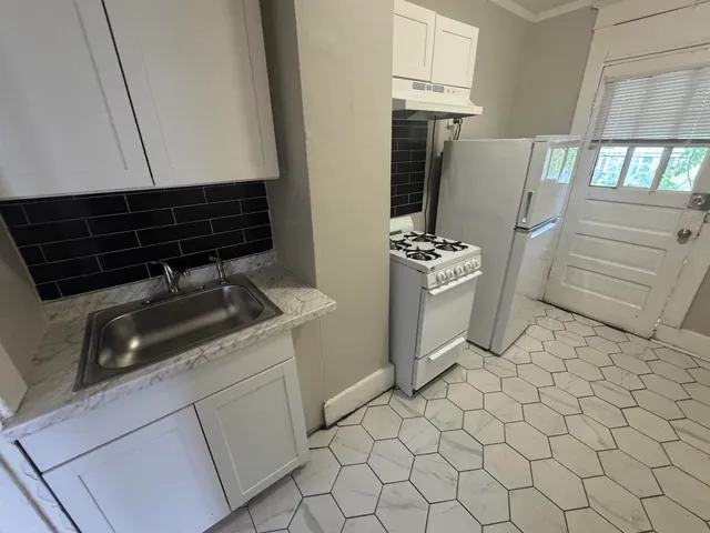 a white refrigerator freezer and a stove sitting inside of a kitchen