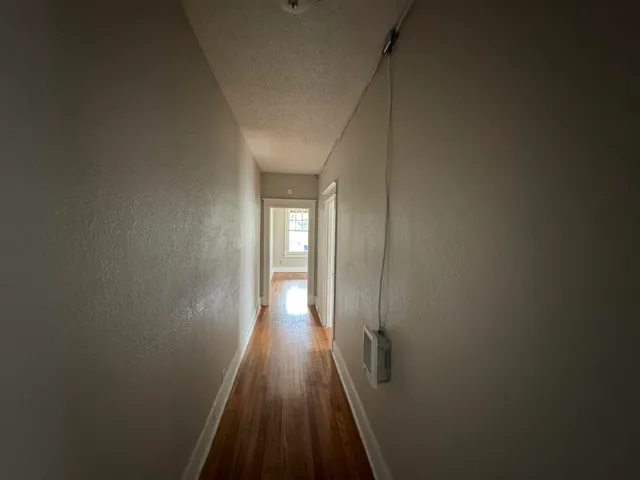 a view of a hallway with wooden floor