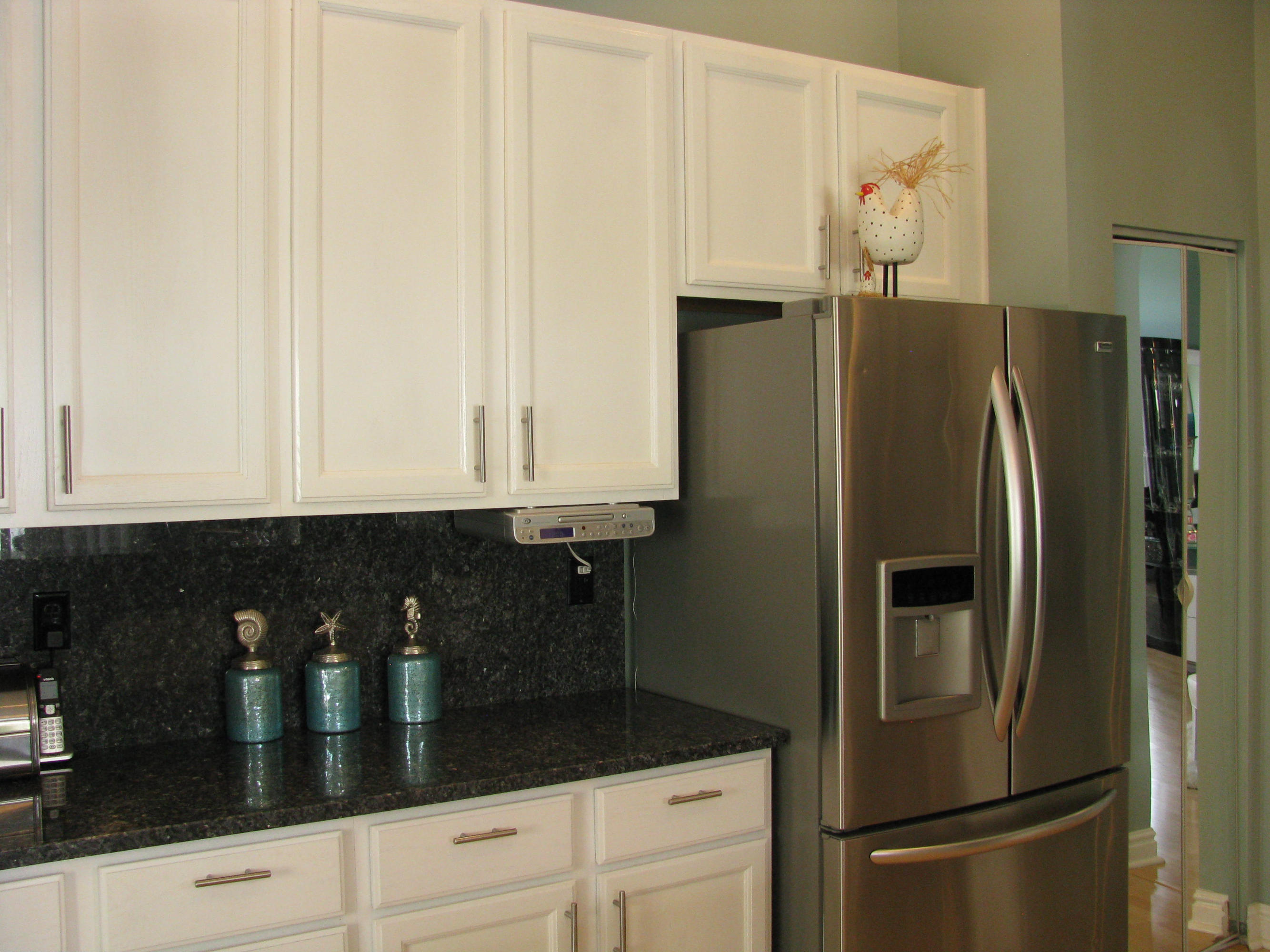 103 Waterbridge Lane Jupiter, FL 33458 - Photo 12 of 47 a kitchen with granite countertop a refrigerator and cabinets