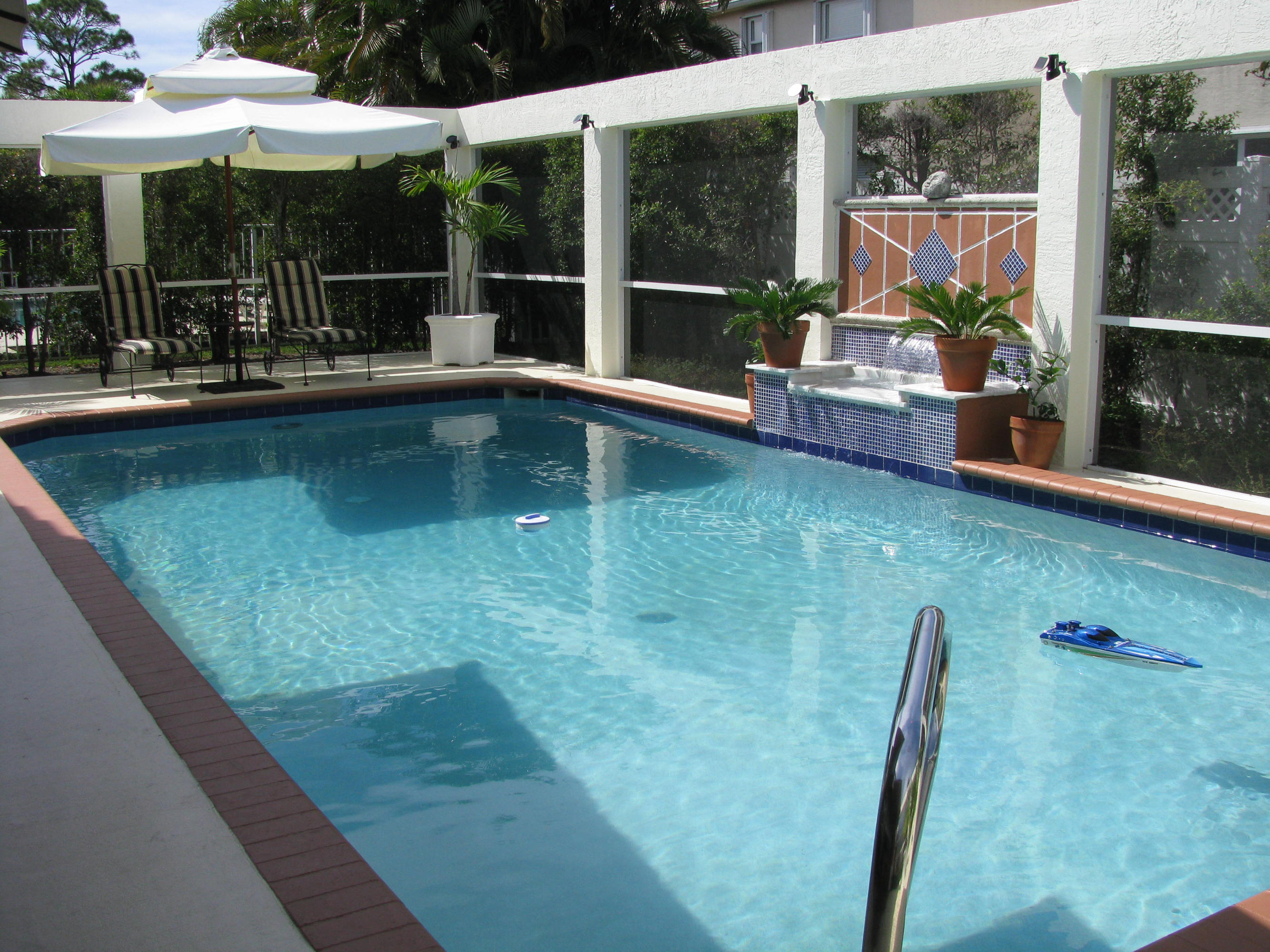 103 Waterbridge Lane Jupiter, FL 33458 - Photo 30 of 47 a view of a swimming pool with a porch and furniture