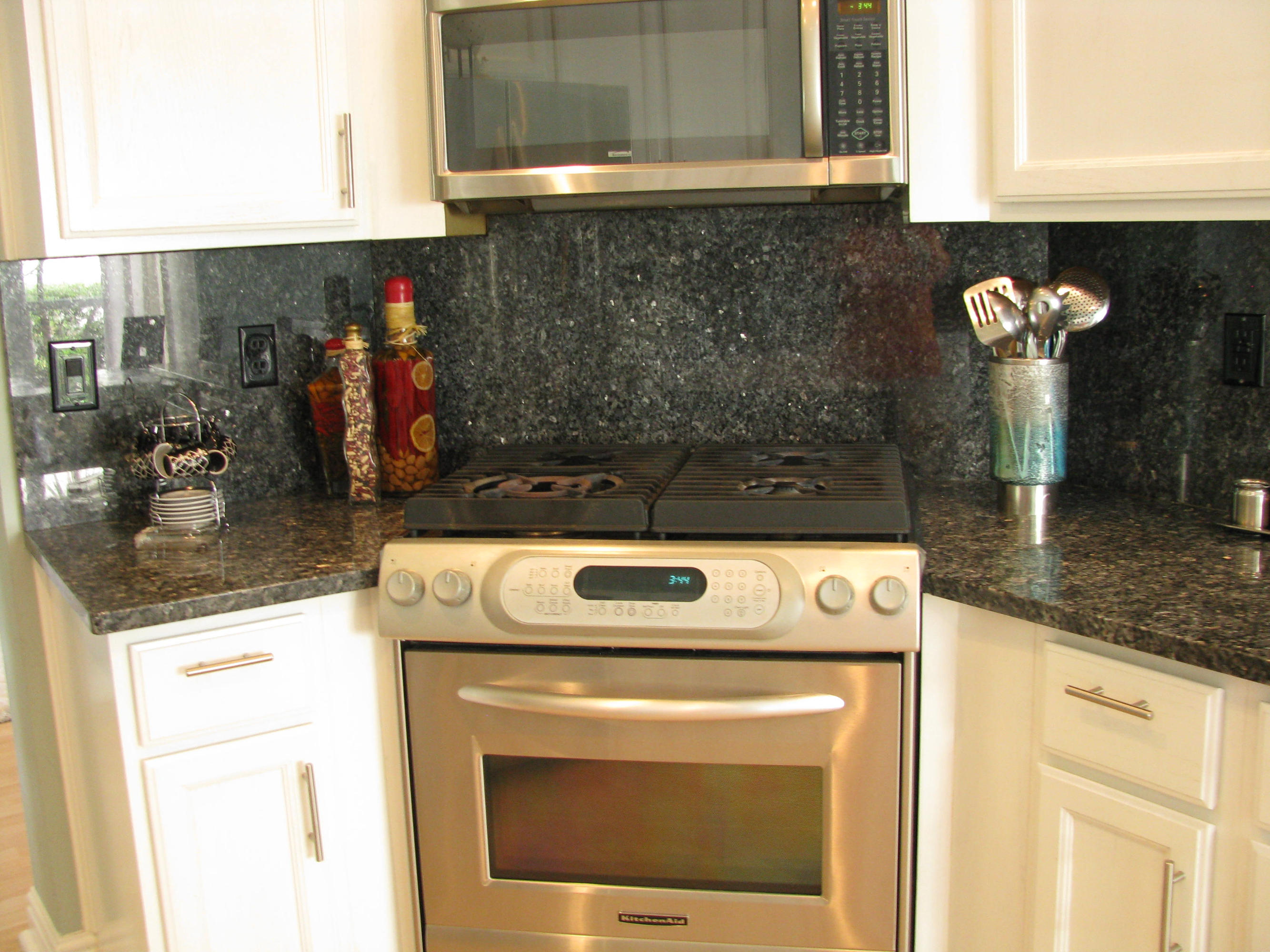 103 Waterbridge Lane Jupiter, FL 33458 - Photo 10 of 47 a kitchen with granite countertop a stove and a microwave