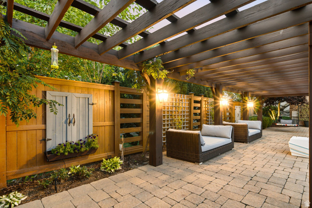 12308 Mariah Circle Draper, UT 84020 - Photo 271 of 293 Expansive stone paver patio featuring a wooden pergola, built-in outdoor lighting, and a privacy fence with decorative trellis panels