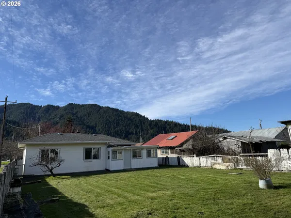 a view of a house with pool and a yard