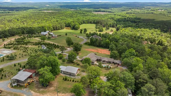 an aerial view of residential houses with outdoor space and trees