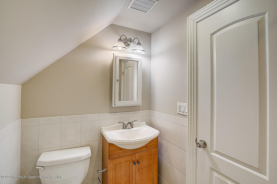 257 Lloyd Road Aberdeen, NJ 07747 - Photo 19 of 46 a bathroom with a toilet sink and mirror