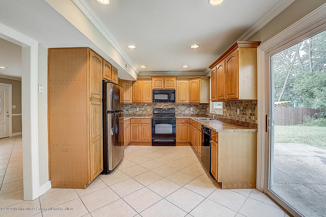 257 Lloyd Road Aberdeen, NJ 07747 - Photo 2 of 46 a kitchen with stainless steel appliances granite countertop a refrigerator and a stove top oven