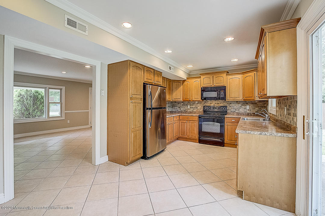257 Lloyd Road Aberdeen, NJ 07747 - Photo 4 of 46 a kitchen with a refrigerator a stove top oven and kitchen island