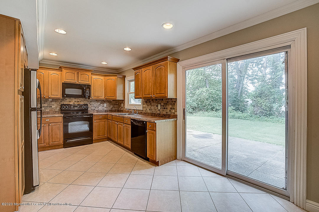 257 Lloyd Road Aberdeen, NJ 07747 - Photo 5 of 46 a kitchen with granite countertop a refrigerator and stainless steel appliances