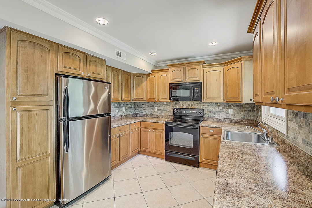 257 Lloyd Road Aberdeen, NJ 07747 - Photo 7 of 46 a kitchen with granite countertop stainless steel appliances a refrigerator sink stove microwave and cabinets