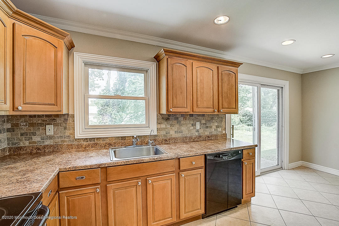 257 Lloyd Road Aberdeen, NJ 07747 - Photo 8 of 46 a kitchen with granite countertop cabinets sink and window