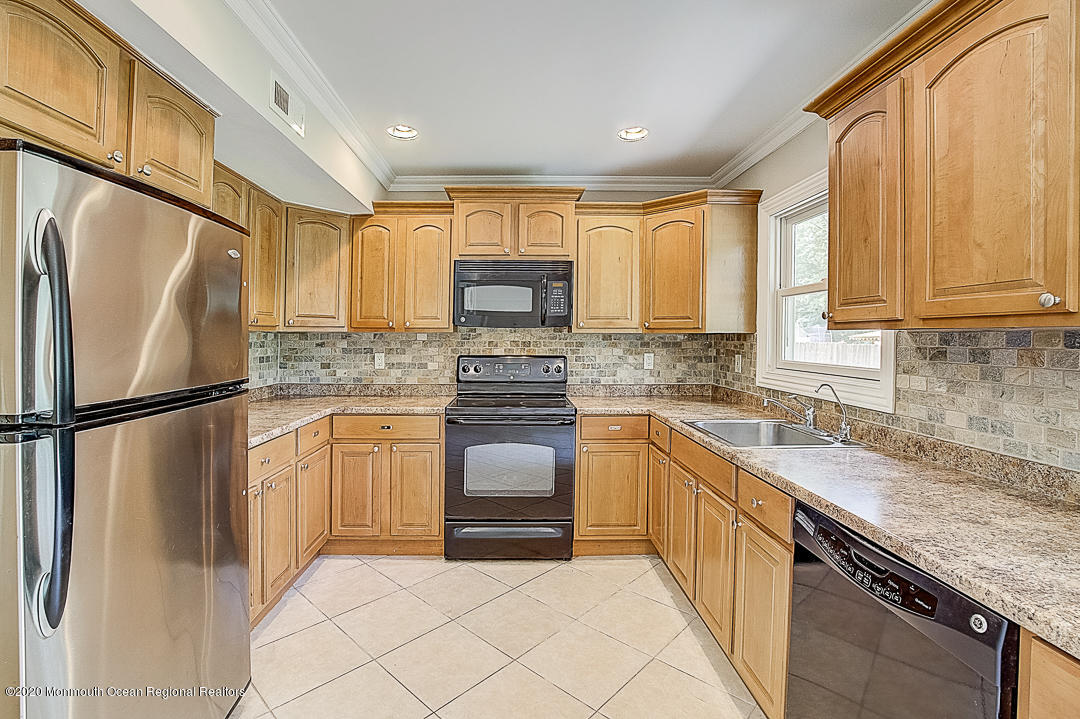 257 Lloyd Road Aberdeen, NJ 07747 - Photo 10 of 46 a kitchen with granite countertop a refrigerator stove top oven and sink