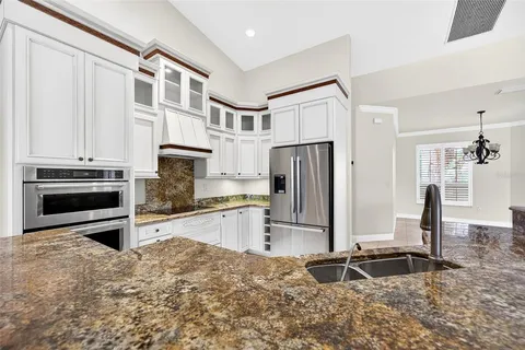 a kitchen with stainless steel appliances granite countertop a sink and cabinets