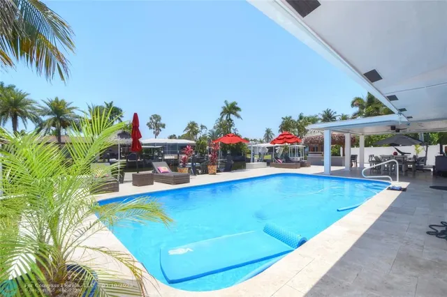 a view of swimming pool with outdoor seating and a potted plant