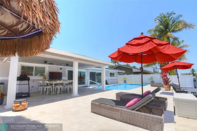 a view of a patio with a table and chairs under an umbrella