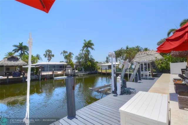 an aerial view of a house with swimming pool having outdoor seating