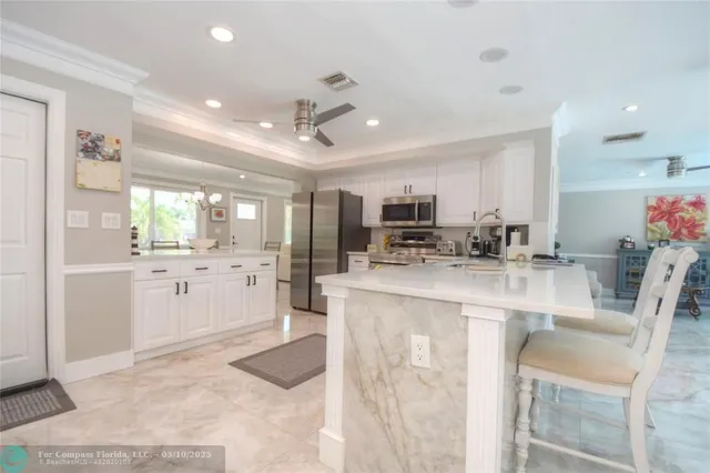 a kitchen with stainless steel appliances kitchen island granite countertop a refrigerator and a stove top oven