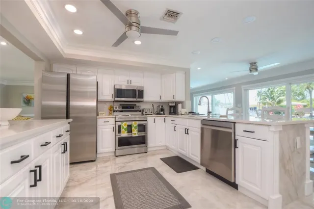 a kitchen with kitchen island granite countertop appliances cabinets and a sink