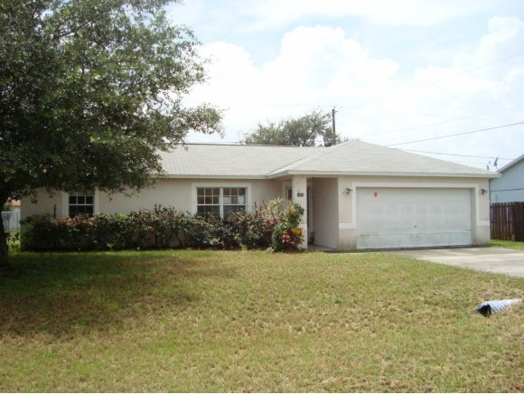 1836 Northeast Cleveland Palm Bay, FL 32905 - Photo 1 of 7 a front view of a house with a yard and garage