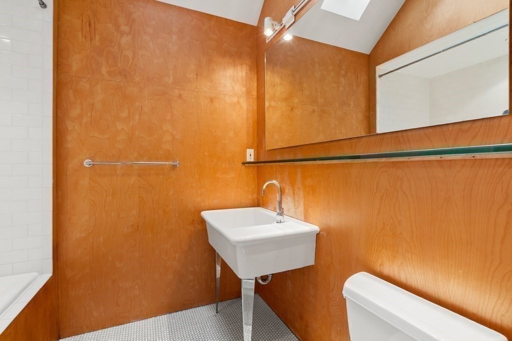 85 Prince Street Newton, MA 02465 - Photo 26 of 37 a bathroom with a sink a mirror and a toilet
