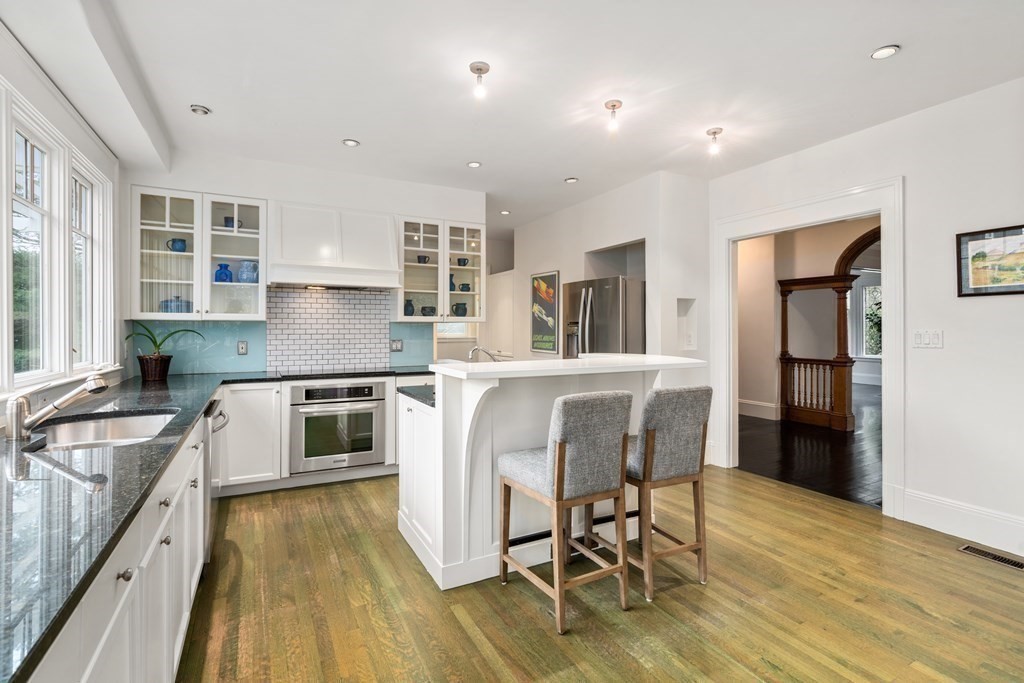 85 Prince Street Newton, MA 02465 - Photo 7 of 37 a kitchen with stainless steel appliances granite countertop a kitchen island hardwood floor sink stove dining table and chairs