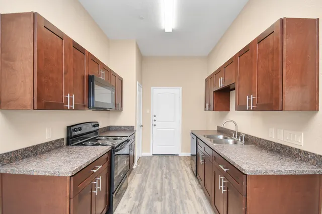 a kitchen with stainless steel appliances granite countertop a sink stove and microwave