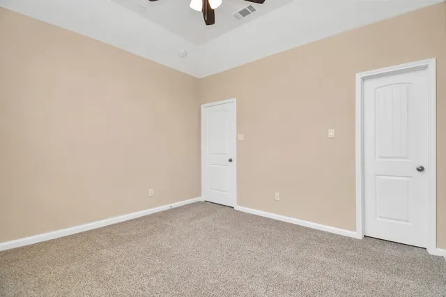 an empty room with fan and windows