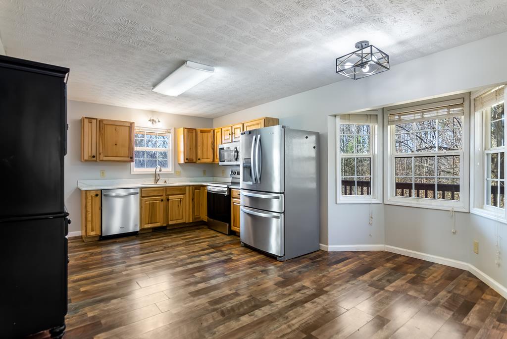 65 Ivy Ridge Ellijay, GA 30536 - Photo 8 of 28 a kitchen with a refrigerator cabinets stainless steel appliances and a large window