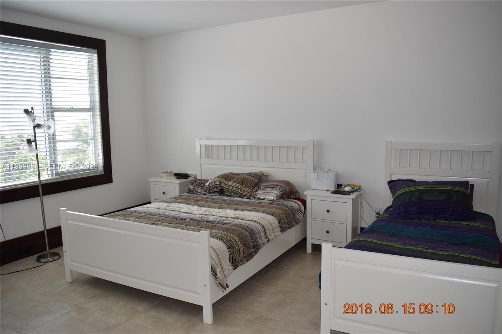 5255 Collins Avenue, Unit 4F Miami Beach, FL 33140 - Photo 11 of 20 a bed sitting in a bedroom next to a window