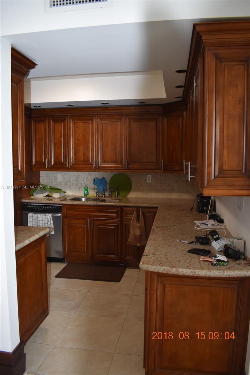 5255 Collins Avenue, Unit 4F Miami Beach, FL 33140 - Photo 4 of 20 a kitchen with stainless steel appliances granite countertop a stove a sink and a microwave