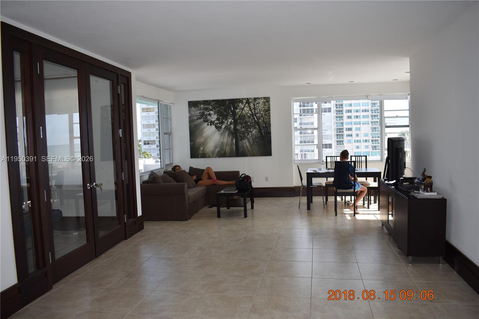 5255 Collins Avenue, Unit 4F Miami Beach, FL 33140 - Photo 5 of 20 a living room with furniture and large windows
