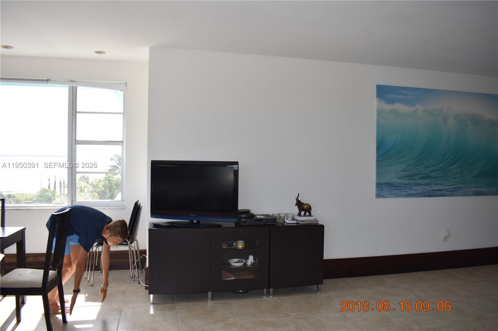 5255 Collins Avenue, Unit 4F Miami Beach, FL 33140 - Photo 7 of 20 a living room with furniture and a flat screen tv