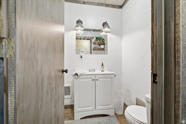1634 West Arimo Road Arimo, ID 83214 - Photo 38 of 89 Bathroom featuring a white vanity with integrated sink, dual wall-mounted sconces, and corrugated metal ceiling detail