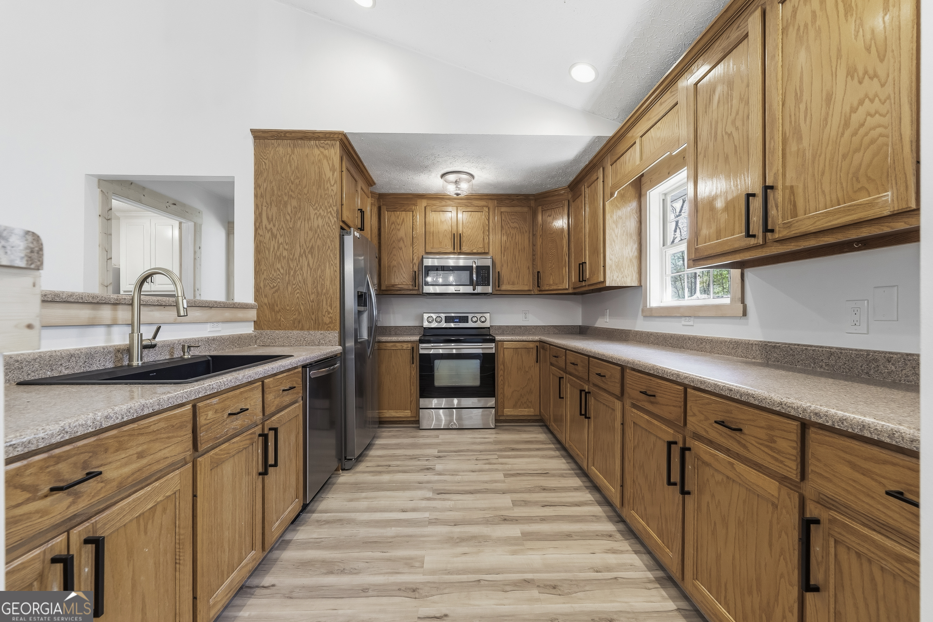 176 Arrowhead Trail Eatonton, GA 31024 - Photo 15 of 45 a large kitchen with stainless steel appliances granite countertop a sink and cabinets