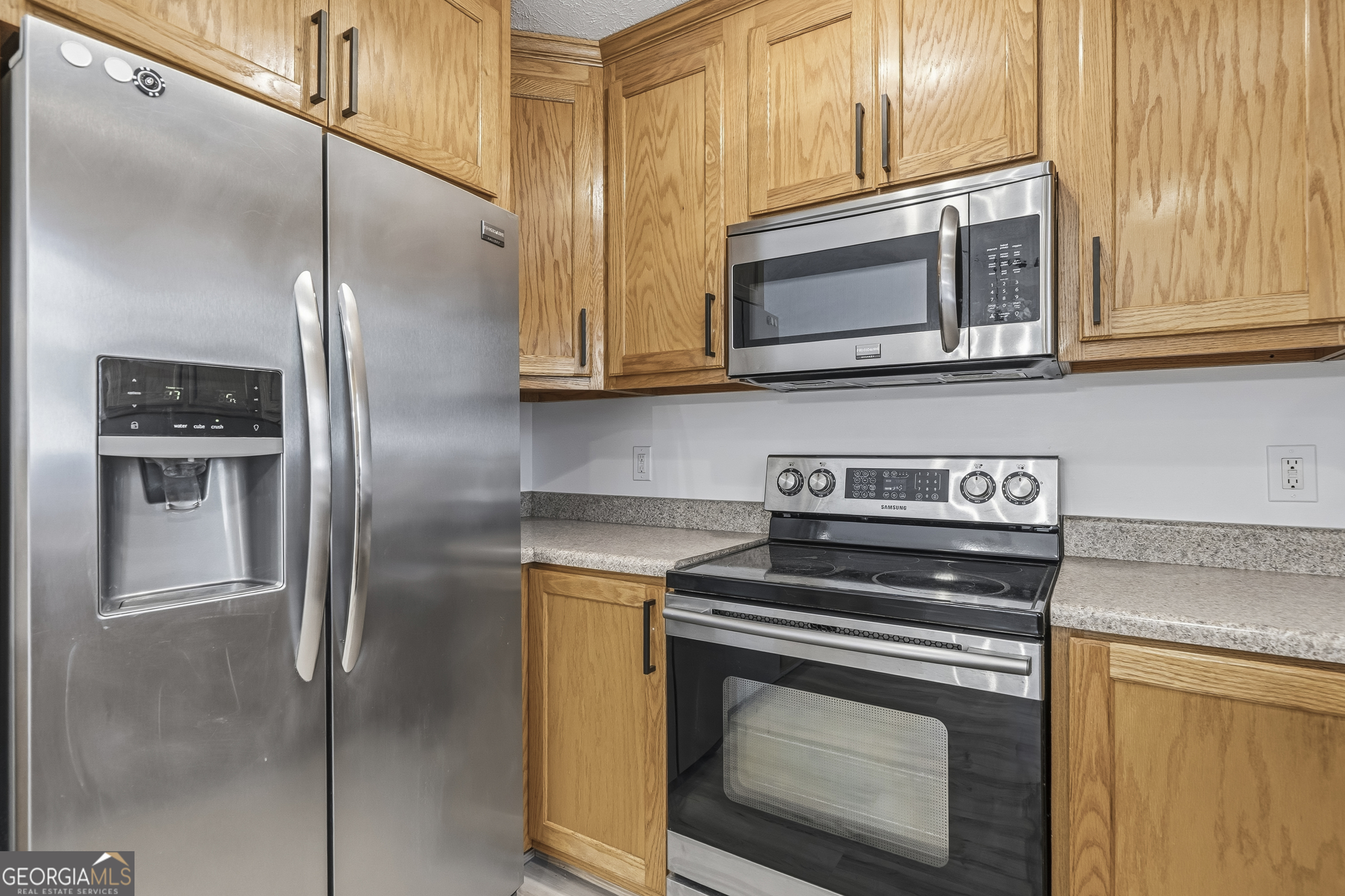 176 Arrowhead Trail Eatonton, GA 31024 - Photo 17 of 45 a kitchen with stainless steel appliances granite countertop a stove microwave and refrigerator