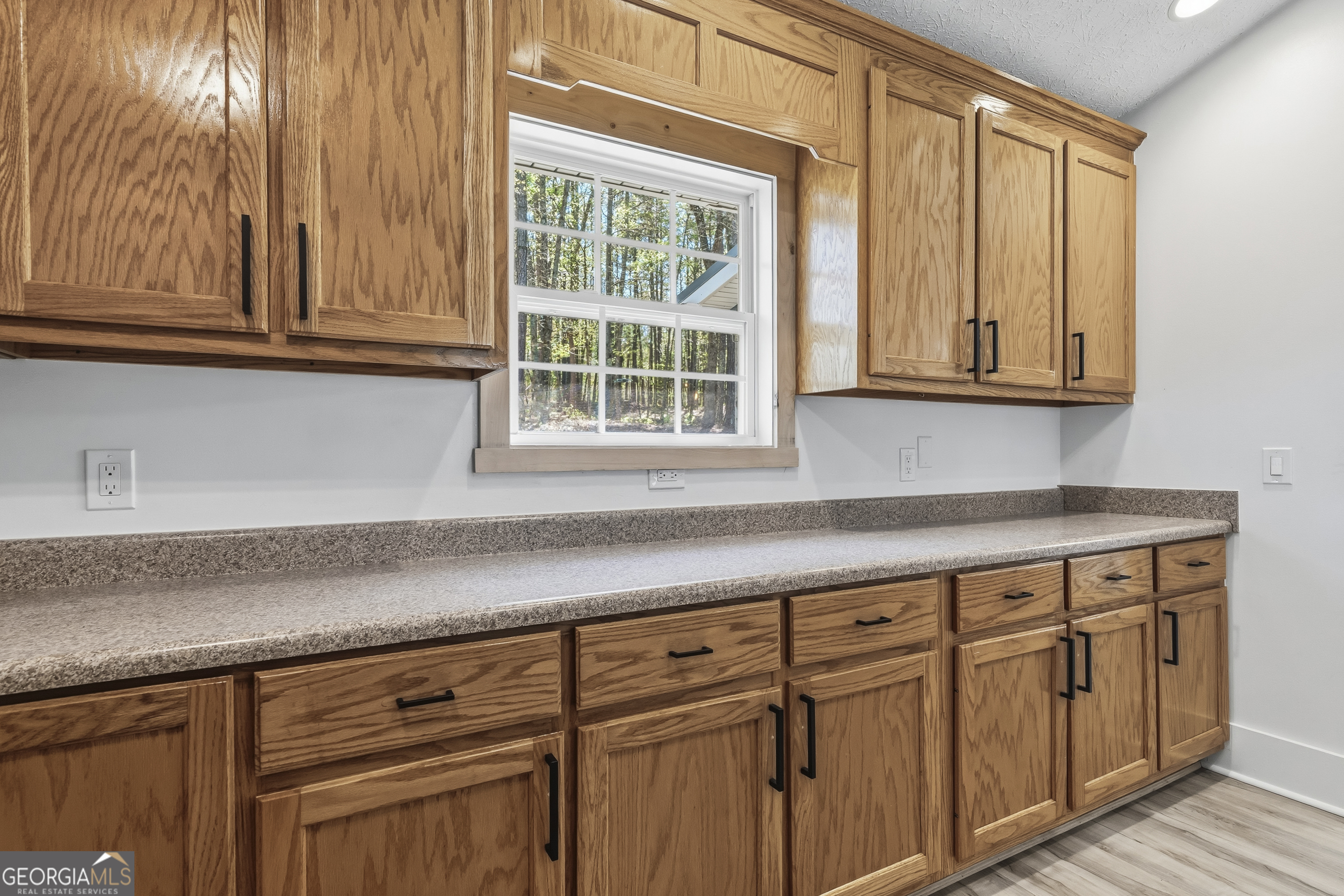 176 Arrowhead Trail Eatonton, GA 31024 - Photo 18 of 45 a kitchen with granite countertop cabinets and window