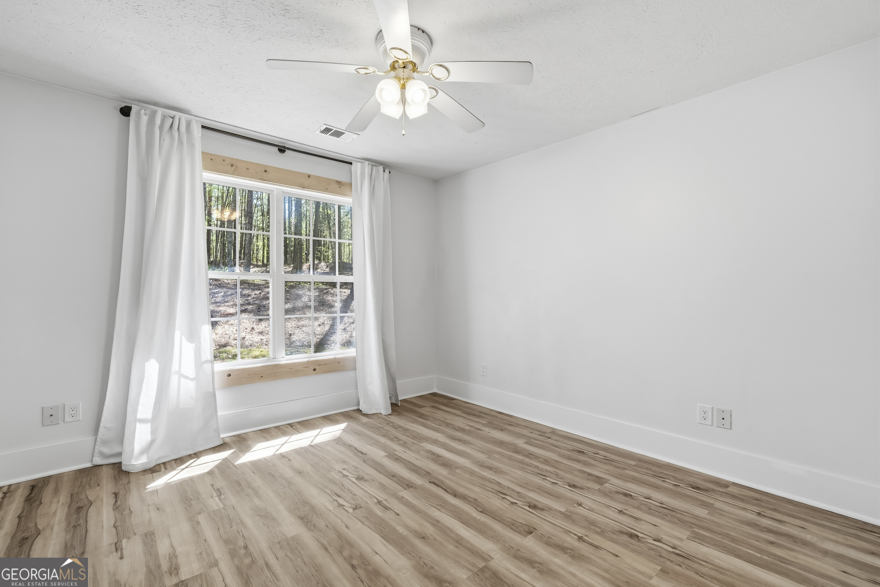 176 Arrowhead Trail Eatonton, GA 31024 - Photo 20 of 45 a view of wooden floor and windows in a room