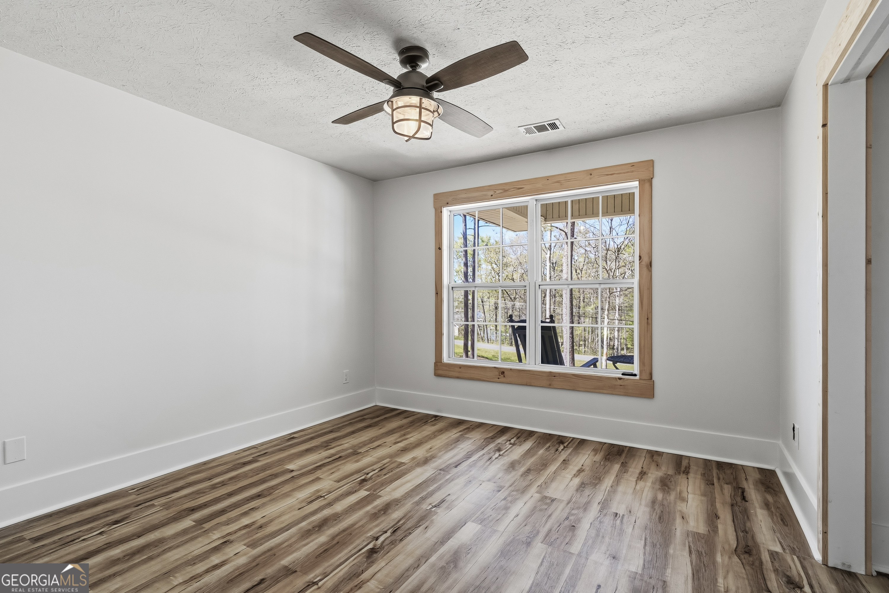 176 Arrowhead Trail Eatonton, GA 31024 - Photo 23 of 45 an empty room with wooden floor and windows