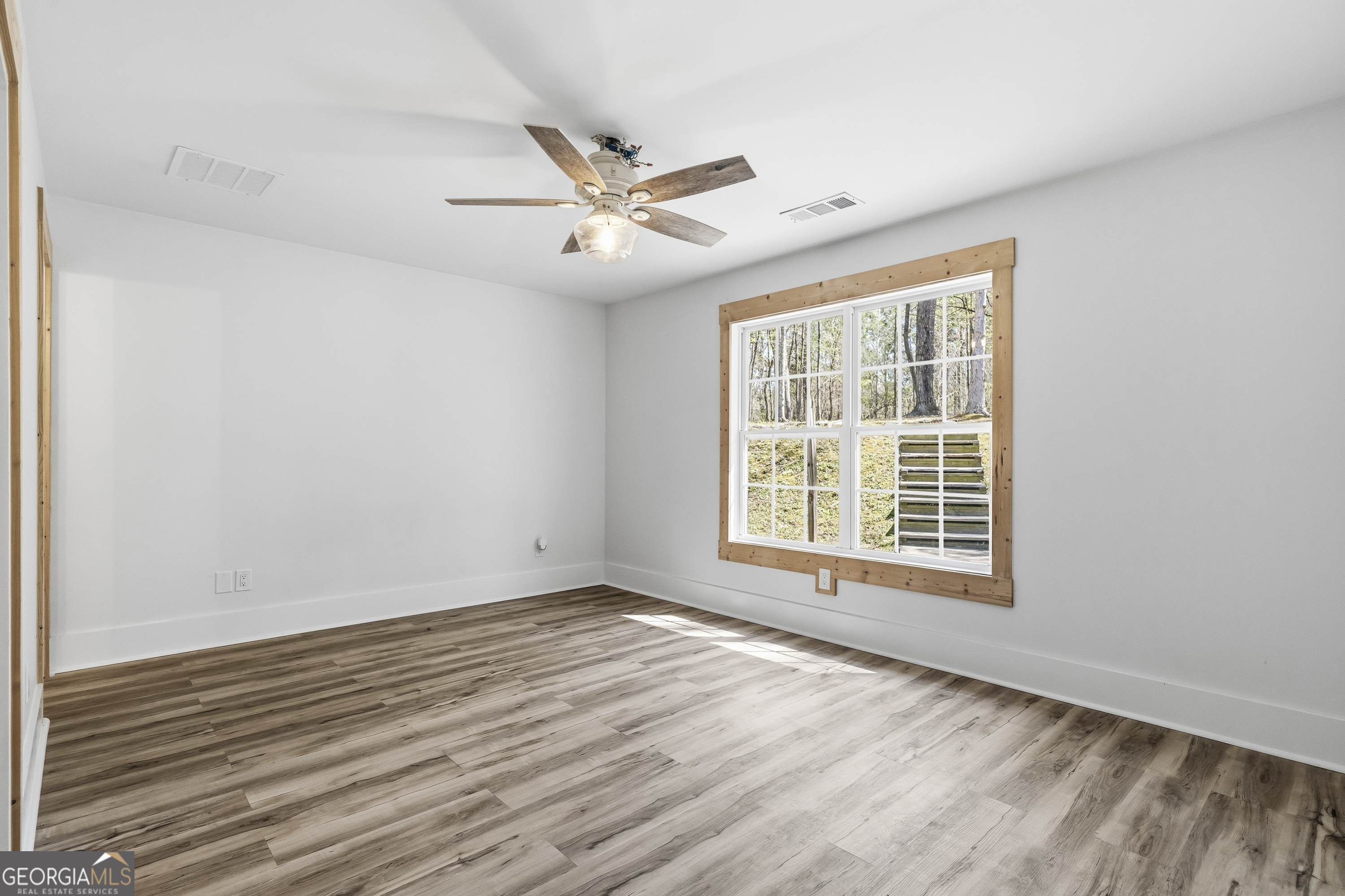 176 Arrowhead Trail Eatonton, GA 31024 - Photo 27 of 45 a view of an empty room with wooden floor and a window