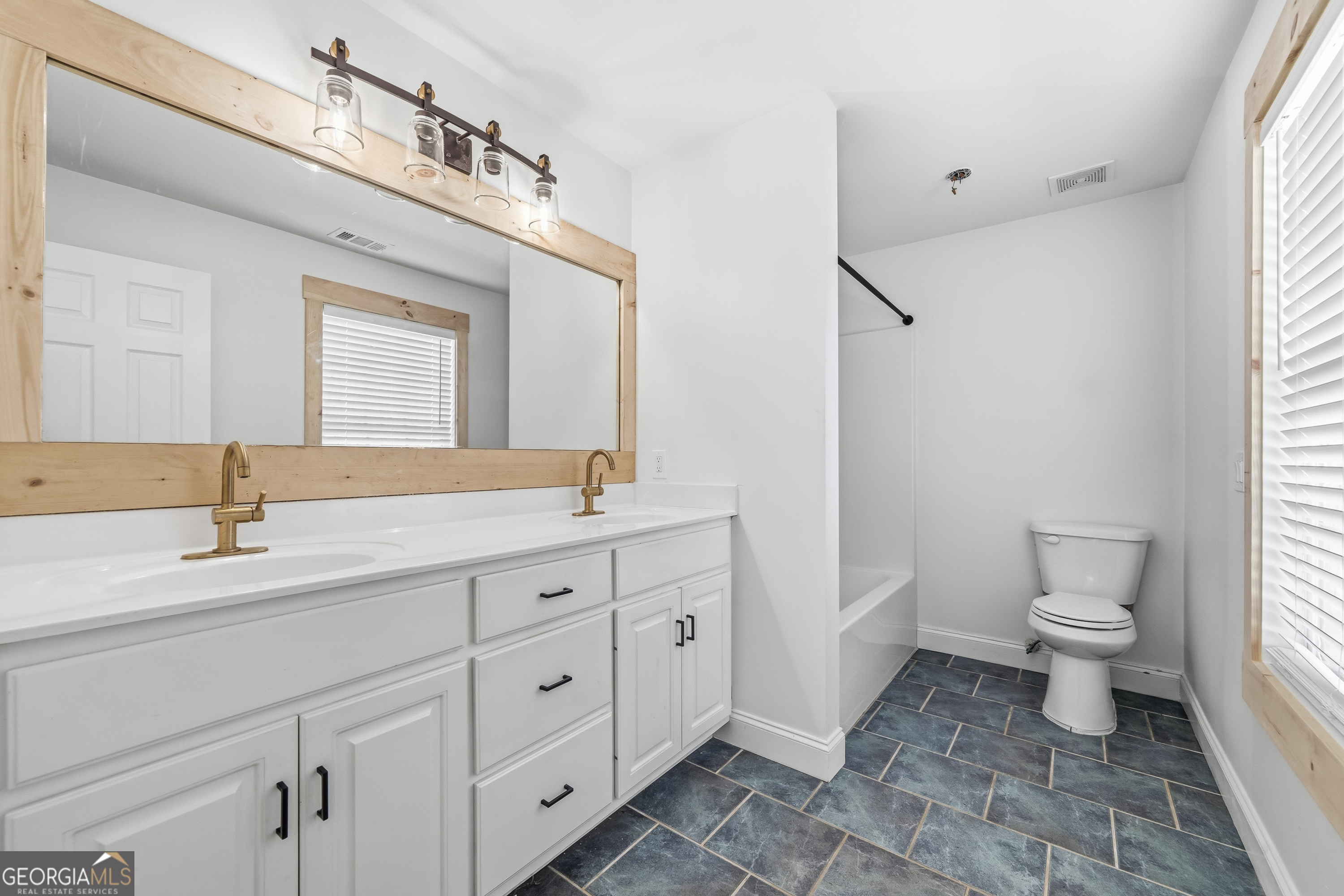 176 Arrowhead Trail Eatonton, GA 31024 - Photo 29 of 45 a spacious bathroom with a granite countertop sink mirror and toilet