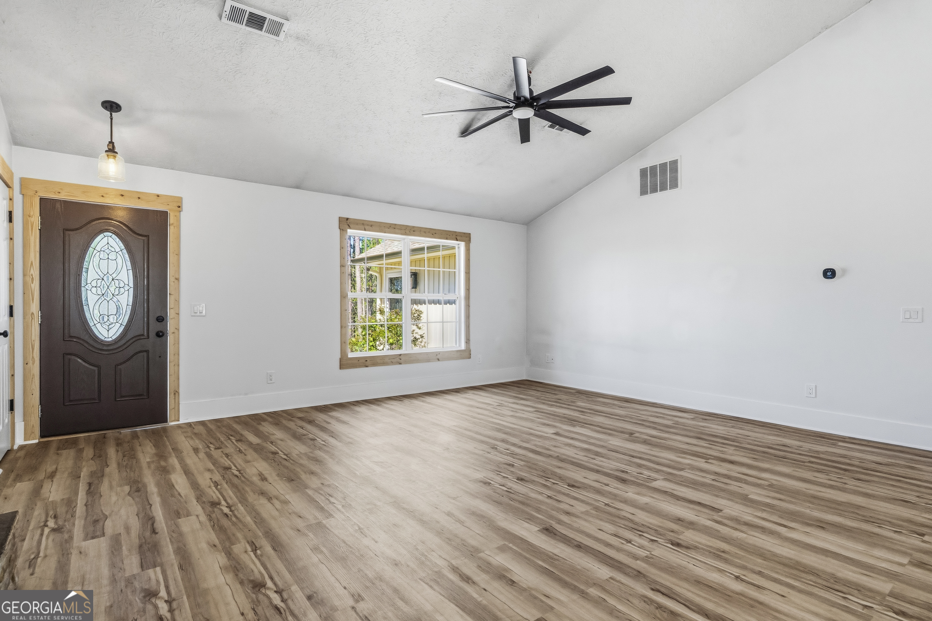 176 Arrowhead Trail Eatonton, GA 31024 - Photo 8 of 45 a view of a hallway with wooden floor and a window